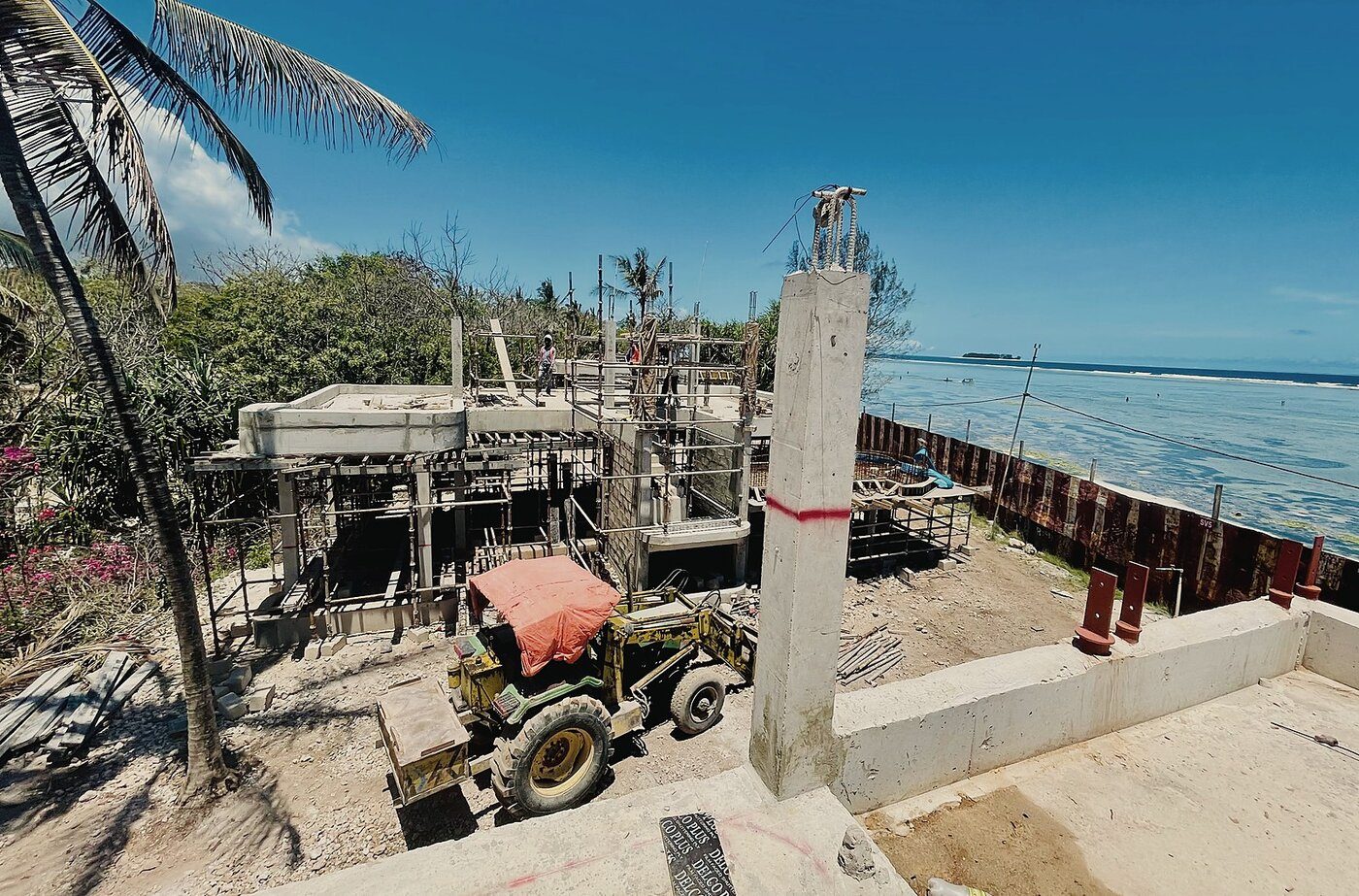 Construction in progress on the Zanzibar coast — foundations and scaffolding beside the water