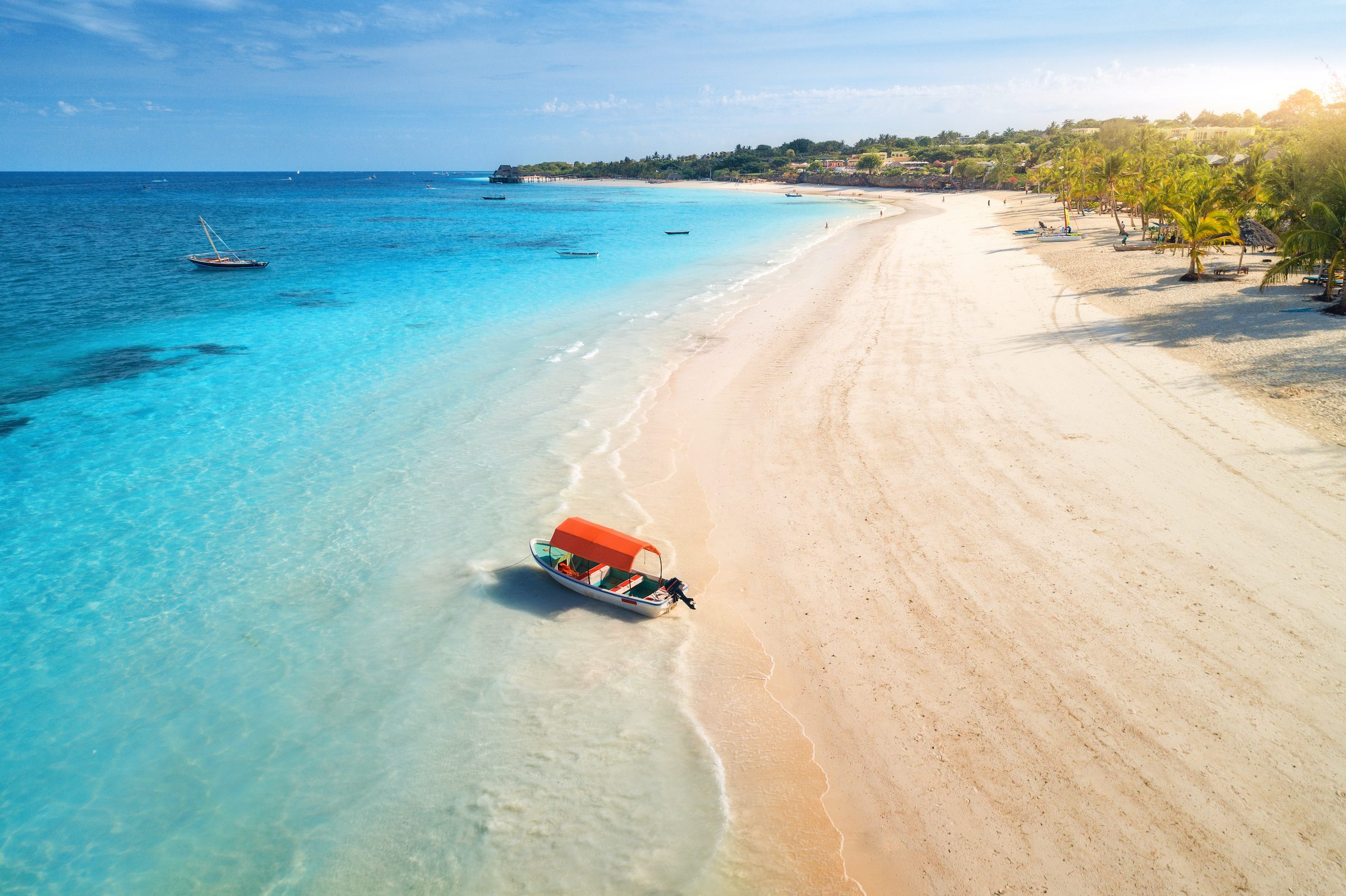 Aerial view of a Zanzibar beach — boats, palms and a resort shoreline